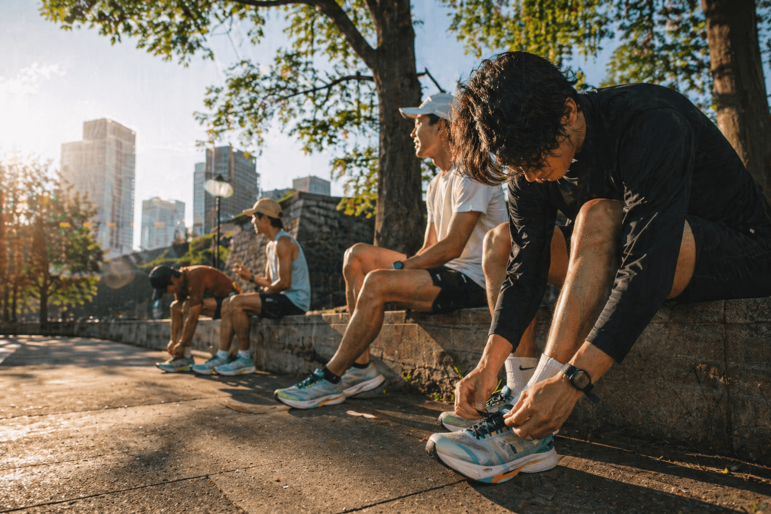 朝の光の中でランニング前にシューズを結ぶランナーたち